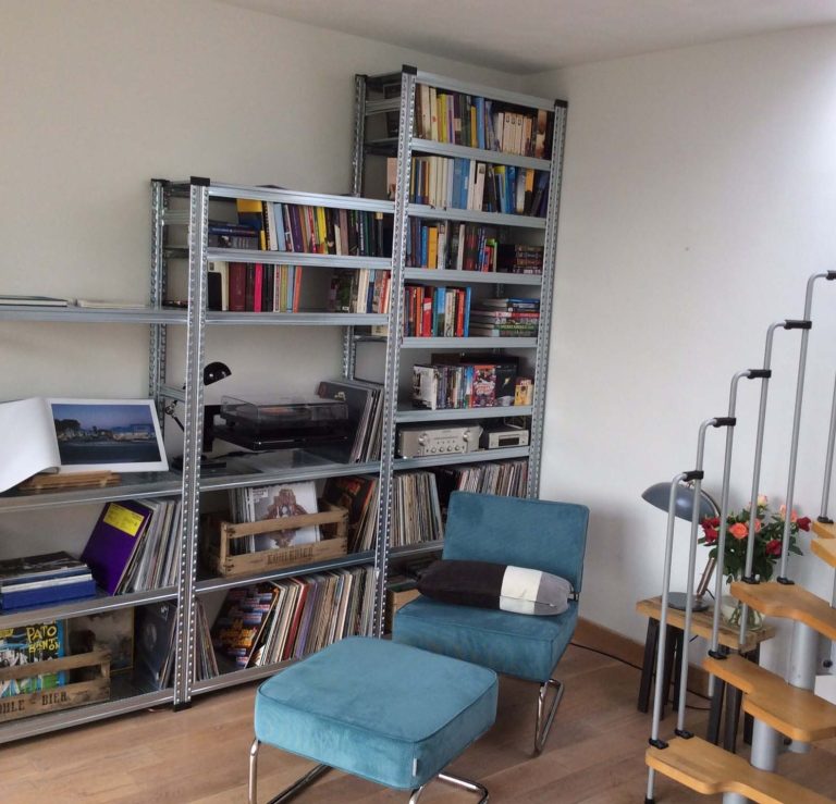 Stellingkast als wandmeubel in woonkamer Stellingkast in de woonkamer gevuld met boeken, platenspeler, vinylplaten en accessoires.