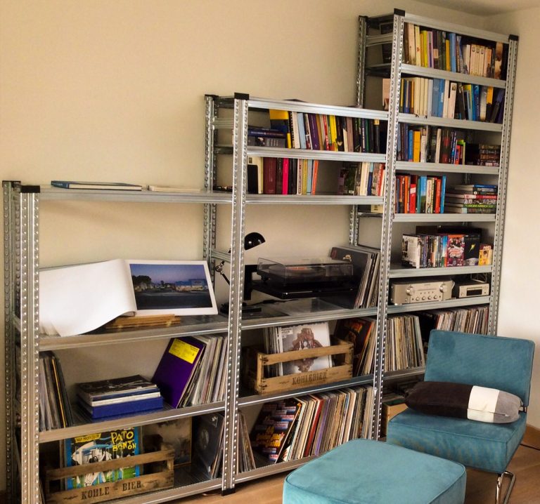 Stellingkast als wandmeubel in woonkamer Stellingkast in de woonkamer gevuld met boeken, platenspeler, vinylplaten en accessoires.